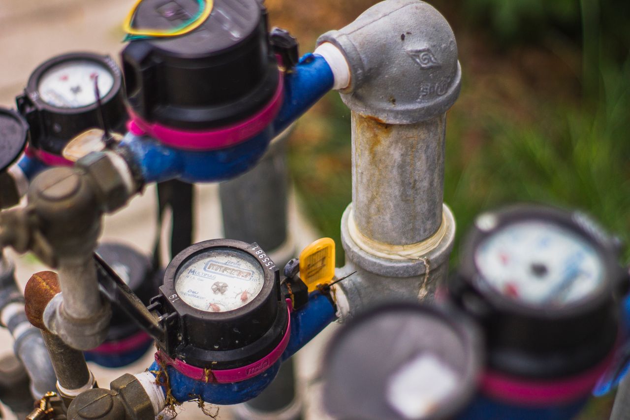 Services Detailed image of industrial water pressure gauges and pipes in an outdoor setting.